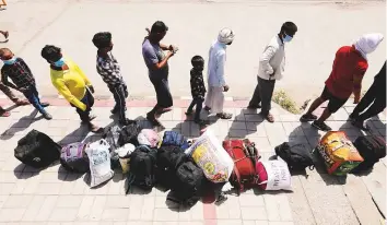  ?? Reuters ?? Migrant workers and their families on way to board a train to their home state of Uttar Pradesh, during virus-induced lockdown in New Delhi.