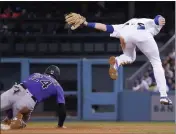  ?? MARK J. TERRILL – THE ASSOCIATED PRESS ?? The Rockies’ Ryan McMahon, left, steals second as Dodgers second baseman Gavin Lux attempts a late tag after taking a high throw in the seventh inning.