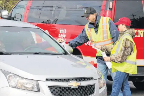  ?? CAROLE MORRIS-UNDERHILL PHOTOS ?? Veteran firefighte­r Fred Rogers teamed up with Parker DeMont to help collect funds during the Oct. 20 toll road in Windsor.