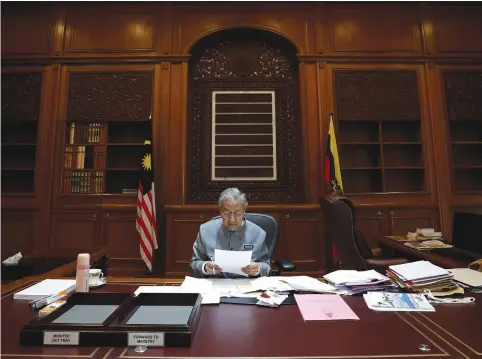  ??  ?? MALAYSIA’S PRIME MINISTER Mahathir Mohamad works at his office in Putrajaya, Malaysia.