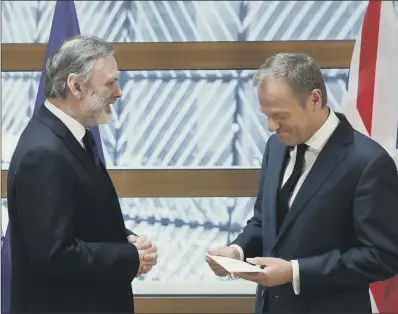  ?? PICTURE: YVES HERMAN/AP ?? ‘A SAD DAY’: British diplomat Tim Barrow, left, delivers Theresa May’s Article 50 letter to EU Council President Donald Tusk.