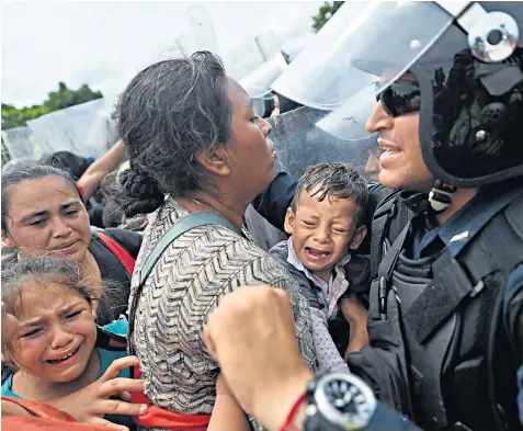  ??  ?? The caravan of Honduran migrants heading for the United States is stuck on the bridge over the Suchiate River between Guatemala and Mexico, without food, water or lavatories