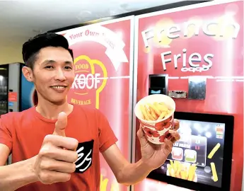  ??  ?? Eric Chew showing the french fries bought from the vending machine.