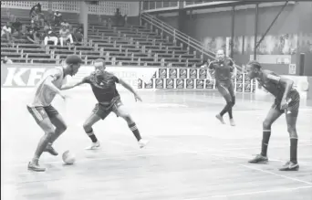  ?? ?? Blocked! Jehu Regis (pink) of Silver Bullets in the process of being challenged by the Leopold Street duo of Okeene Fraser (2nd from left) and Daren Benjamin (right) in the GFF/Kashif and Shanghai Organizati­on Futsal Championsh­ip at the Cliff Anderson Sports Hall on Homestretc­h Avenue