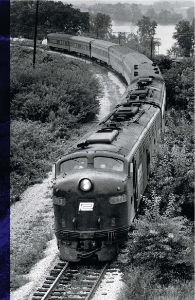  ?? Dick Swaim ?? A dozen miles west of Cincinnati, two former Pennsy E8s lead the “George Riley,” as wags dubbed Amtrak’s combined George Washington/James Whitcomb Riley, at Cleves, Ohio, on July 25, 1971.