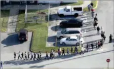  ?? MIKE STOCKER — SOUTH FLORIDA SUN-SENTINEL VIA AP ?? Students are evacuated by police from Marjorie Stoneman Douglas High School in Parkland, Fla., on Wednesday after a shooter opened fire on the campus.