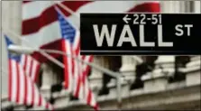  ??  ?? The Wall Street sign near the front of the New York Stock Exchange. Human traders have maintained their role in the foreign exchange market while disappeari­ng in areas such as equities because most trading takes place away from exchanges.