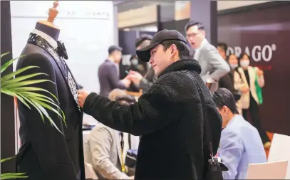  ?? PROVIDED TO CHINA DAILY ?? A visitor checks out products during the spring edition of the Intertexti­le Shanghai Apparel Fabrics trade fair held at the city’s National Exhibition and Convention Center on March 29.