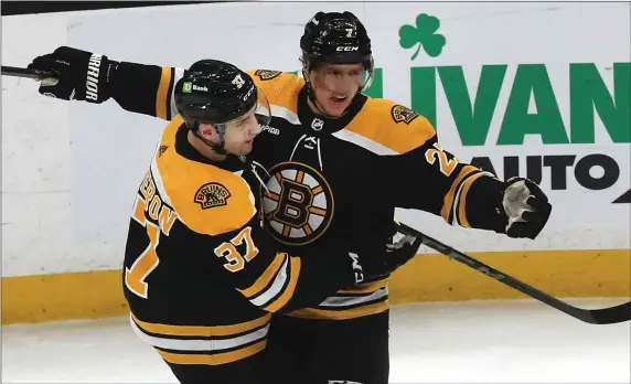  ?? STAFF PHOTO BY NANCY LANE — BOSTON HERALD ?? Boston Bruins defenseman Hampus Lindholm, right, celebrates his goal with Patrice Bergeron during the first period of a Jan. 22 game against the San Jose Sharks in Boston.