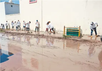  ??  ?? Vecinos de las colonias anegadas colaboran en las labores de limpieza.