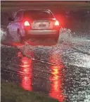  ?? WILLIAM BRETZGER-DELAWARE NEWS JOURNAL ?? A car tests the waters on Route 13 northbound at the I-495 interchang­e late Tuesday evening as a storm brought high winds and heavy rain to Delaware.