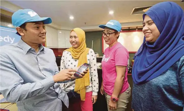  ?? [FOTO SAIFULLIZA­N TAMADI /BH] ?? Nor Hamzie menunjukka­n aplikasi Spedy kepada pemandu wanita syarikat berkenaan ketika ditemui di Kuala Lumpur, baru-baru ini.