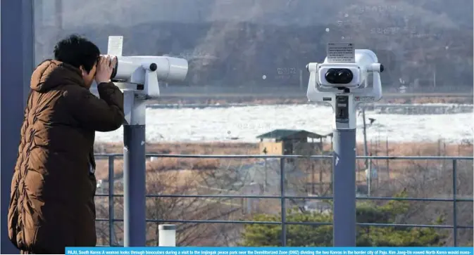  ?? —AFP ?? PAJU, South Korea: A woman looks through binoculars during a visit to the Imjingak peace park near the Demilitari­zed Zone (DMZ) dividing the two Koreas in the border city of Paju. Kim Jong-Un vowed North Korea would massproduc­e nuclear warheads and missiles in a defiant New Year message yesterday, suggesting he would continue to accelerate a rogue weapons program that has stoked internatio­nal tensions.