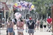  ?? JOHN RAOUX—ASSOCIATED PRESS ?? In this June 16, 2020, file photo, guests required to wear masks because of the coronaviru­s stroll through the Disney Springs shopping, dining and entertainm­ent complex in Lake Buena Vista, Fla. Magic Kingdom and Animal Kingdom will reopen on July 11. In May, the company opened Disney Springs.