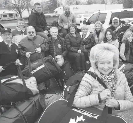  ?? DAX MELMER ?? Kim Spirou, president of the Rotary Club of Essex and leader of the Rotary Mission to Ghana, stands Tuesday with other Rotarians and local volunteers. They’re showing off 53 hockey bags, all stuffed with medical and school supplies, toys and clothing to be donated in Ghana.