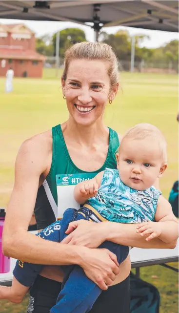  ?? Picture: MATT LOXTON/AAP ?? GAMES-BOUND: Claire Tallent, with her eight-month-old son, Harvey, celebrates after qualifying for the Commonweal­th Games in Adelaide yesterday,