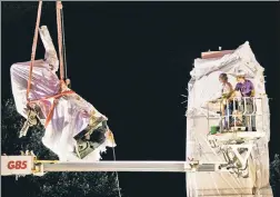  ??  ?? IT’S HISTORY: A work crew removes the Christophe­r Columbus statue in Chicago’s Grant Park in the early hours Friday following chaotic protests amid a plan by President Trump to dispatch federal agents to the city.