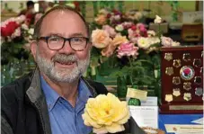  ??  ?? Leo Cooper shows off one of the prize-winning flowers at the rose show.