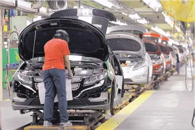  ?? ASSOCIATED PRESS ?? Assembly worker Julaynne Trusel works on a Chevrolet Volt at the General Motors Hamtramck Assembly plant in Hamtramck, Mich. GM announced Monday that it will lay off thousands of factory and white-collar workers in North America and put five plants up for possible closure.