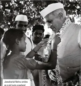  ??  ?? Jawaharlal Nehru smiles as a girl puts a garland around his neck. As +ndiaos first priOe minister, he steered the country after it gained independen­ce in 1947