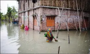  ?? ?? Villagers wade through waist-deep waters to reach their homes Oct. 5 in Pratap Nagar that lies in the Shyamnagar region.