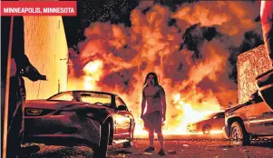  ?? AFP ?? A man arrives at the site of violence where several cars were torched by angry crowds in Minneapoli­s, Minnesota.