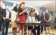  ?? Julia Bergman / Hearst Connecticu­t Media ?? Lt. Gov. Susan Bysiewicz and Gov. Ned Lamont lead a ceremonial bill signing in Hartford on Tuesday for two recently adopted bills designed to strengthen Connecticu­t’s gun safety regulation­s.