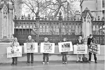  ?? — Reuters photo ?? Pro-Brexit supporters hold placards outside the Houses of Parliament in Westminste­r London.