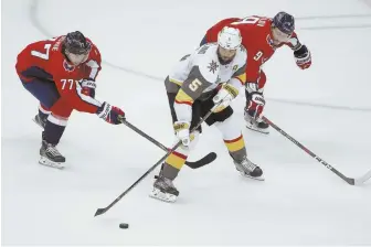  ?? AP PHOTO ?? FEELING THE SQUEEZE: Capitals forward T.J. Oshie (left) and defenseman Dmitry Orlov (right) harrass Golden Knights defenseman Deryk Engelland during Washington’s Game 3 win in the Stanley Cup Finals on Saturday night in Washington.