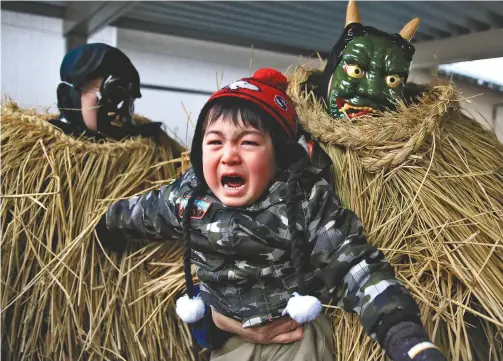  ?? Yomiuri Shimbun photos ?? Top: A child cries while surrounded by Amahage deities in the Mega district of Yuza, Yamagata Prefecture, on Jan. 3.