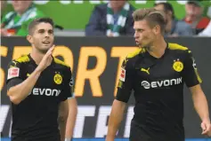  ?? Peter Steffen / Associated Press ?? Dortmund’s Christian Pulisic (left), who plays for the U.S. national team, celebrates scoring the first goal against Wolfsburg.