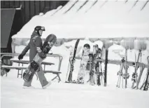  ??  ?? A snowboarde­r heads to the Solitude Food Court just off the American Eagle lift at Copper Mountain.