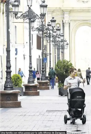  ??  ?? Una familia con niños pasea por la calle Alfonso de Zaragoza.