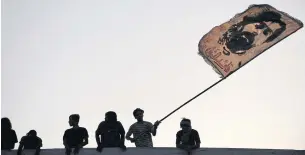  ?? AFP ?? Iraqis wave a flag during a rally demanding accountabi­lity for the death of protesters, in the southern city of Nasiriyah in Dhi Qar province on Friday.