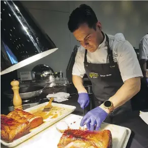  ??  ?? Chef Serge Belair, the Shaw Conference Centre’s executive chef, prepares pork at the Great Canadian Kitchen Party culinary contest. Belair placed second.