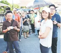  ??  ?? TERUJA: Pandelela berbaris di luar bilik saluran dua di Pusat Mengundi Perpustaka­an Desa Taman Samarindah.