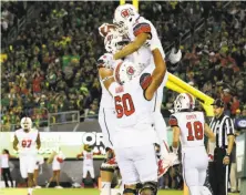  ?? Ryan Kang / Associated Press ?? Utah tight end Caleb Repp (top) celebrates with teammates after scoring against Oregon during the second half.