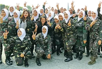  ??  ?? THEY COME IN PEACE — Flashing peace signs, the all-female Civil Relations Company (CRC) from the military and police services prepares to leave for Marawi City at the Villamor Airbase in Pasay City yesterday. Their job is to facilitate the recovery,...