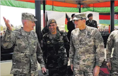  ?? Lolita Baldor ?? The Associated Press U.S. Gen. John Nicholson, top U.S. commander in Afghanista­n, left, talks Sunday with Col. Khanullah Shuja, an Afghan commander, and U.S. Gen. Joseph Votel, head of U.S. Central Command, at Camp Morehead in Afghanista­n.