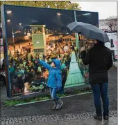  ?? SEAN GALLUP / GETTY IMAGES ?? Left: Visitors look at photograph­s from 1989 at Bernholmer Bridge, where on Nov. 9, 1989, people first crossed unhindered from East Berlin into West Berlin.