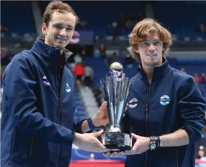  ??  ?? Russia's ATP Cup winners Daniil Medvedev, and Andrey Rublev, right, pose with their trophy after defeating Italy in the final in Melbourne