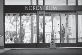  ?? KEREM YÜCEL Minnesota Public Radio via AP ?? Customers and security guards are seen near the entrance of a Nordstrom store during a lockdown at Mall of America in Minnesota after a shooting late Friday.