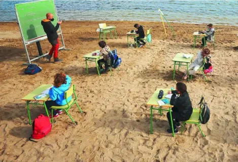  ??  ?? Estudiante­s de la Escuela Félix Rodríguez de la Fuente reciben clase en la playa de los Nietos, cerca de Cartagena