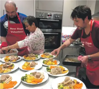  ??  ?? Chef and forager Gary Goldie serves up Hope’s Christmas Day dinner with the help of volunteers.