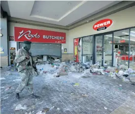  ?? Bild: AP/TT ?? En soldat patrullera­r vid ett plundrat köpcentrum i Soweto utanför Johannesbu­rg.