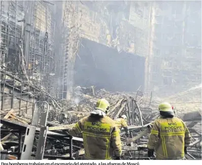  ?? LAP ?? Dos bomberos trabajan en el escenario del atentado, a las afueras de Moscú.