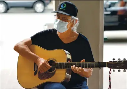  ?? DOUG DURAN — STAFF PHOTOGRAPH­ER ?? Evacuee John Culloty plays his guitar at the evacuation center in the Santa Cruz Civic Auditorium in Santa Cruz on Friday. Like many others, Culloty had to evacuate because of the CZU Lightning Complex Fire burning in the mountains of Santa Cruz and San Mateo counties.