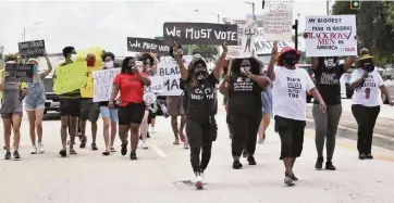  ?? CARL JUSTE cjuste@miamiheral­d.com ?? Protesters march east on Atlantic Boulevard toward Pompano City Hall on Sunday as part of a protest organized by Black Lives Matter and in protest of the killing of Bree Black in Pompano.