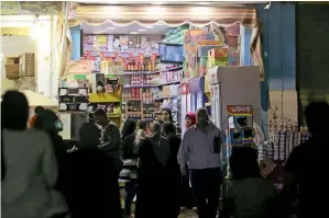  ?? Reuters ?? SHOPPING TIME: People gather in front of a shop during curfew hours in Cairo amidst concerns about the spread of coronaviru­s in Cairo. —