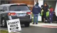  ?? Erik Trautmann / Hearst Connecticu­t Media ?? Volunteers hand out food to parents at Tracey Elementary School in Norwalk on Tuesday after bus stop deliveries were suspended.